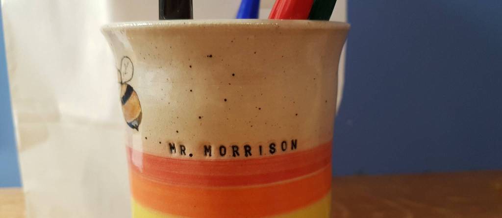 Cover Photo of a pen pot with 'Mr Morrison' written on the side.