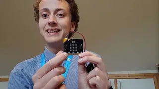 Picture of Mr Morrison holding a micro:bit pointing to the pins.